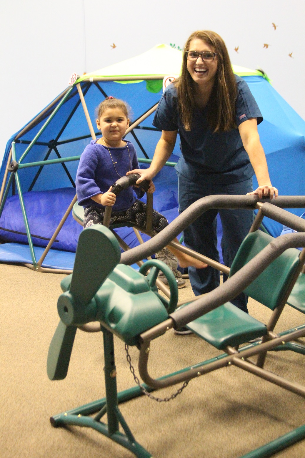 Therapist and girl on airplane teeter totter