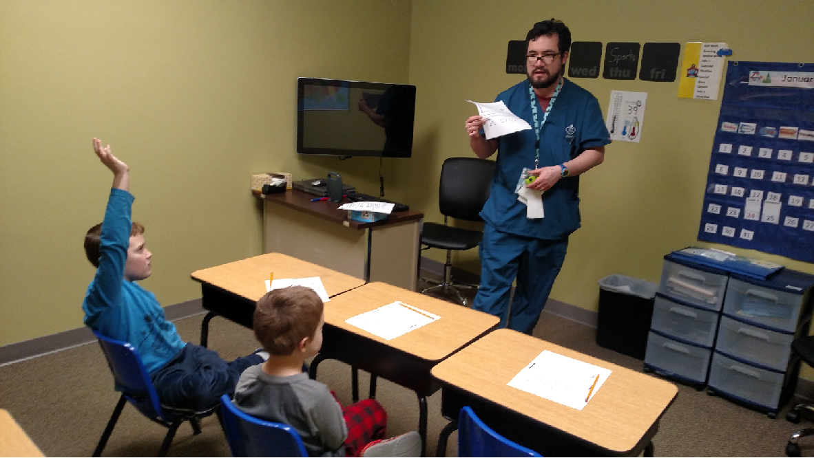 Classroom group activity, boy raising hand