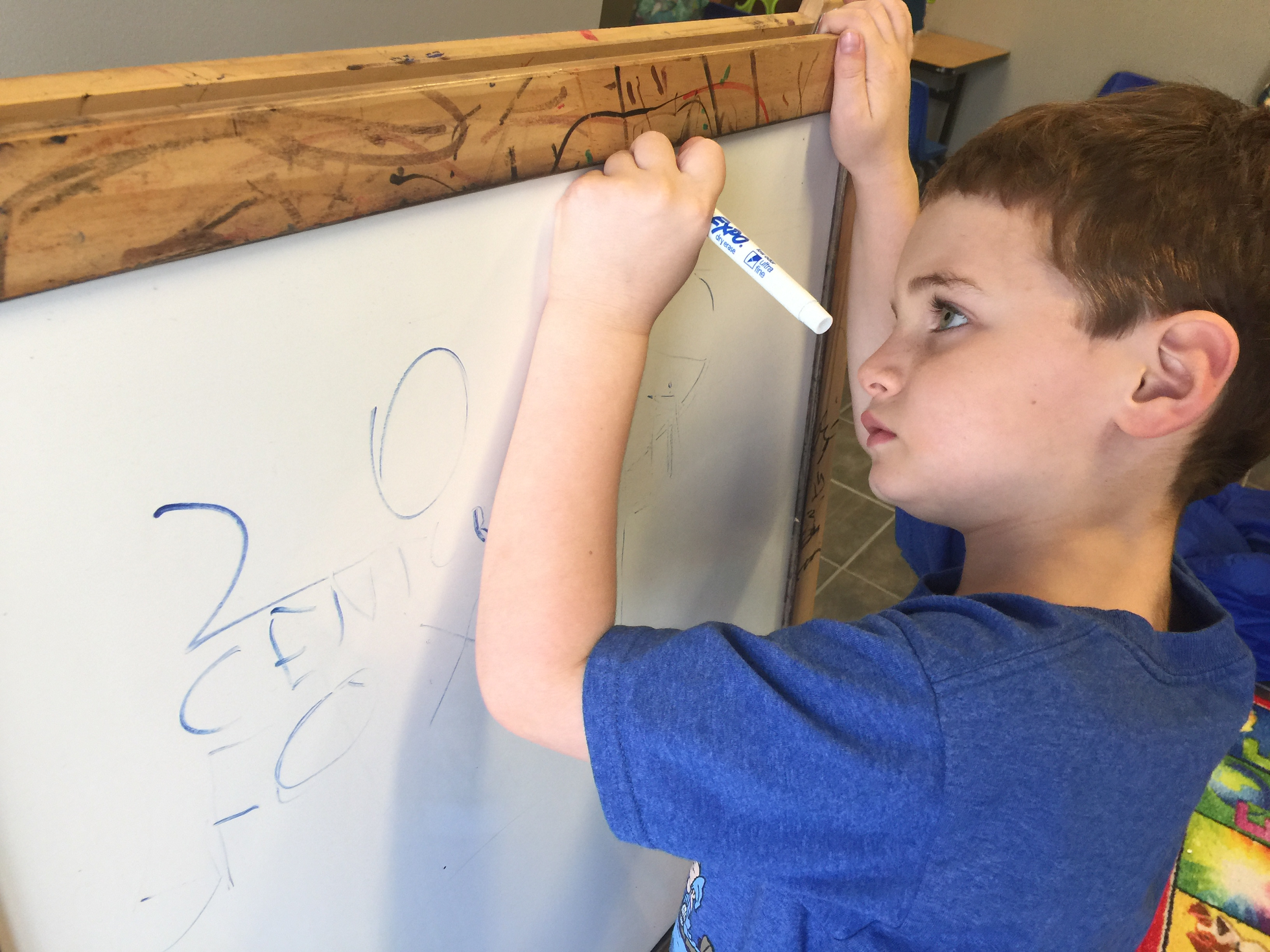 Boy writing on whiteboard